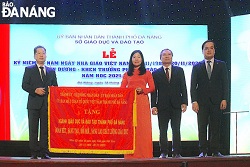 Ủy viên Trung ương Đảng, Bí thư Thành ủy, Trưởng đoàn đại biểu Quốc hội thành phố Nguyễn Văn Quảng (bên trái) tặng bức trướng cho ngành giáo dục và đào tạo thành phố. Ảnh NGỌC HÀ